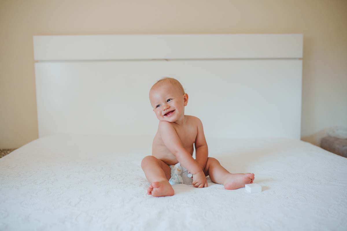 Momento de cumplicidade e sorrisos na reportagem fotográfica de batizado de família.