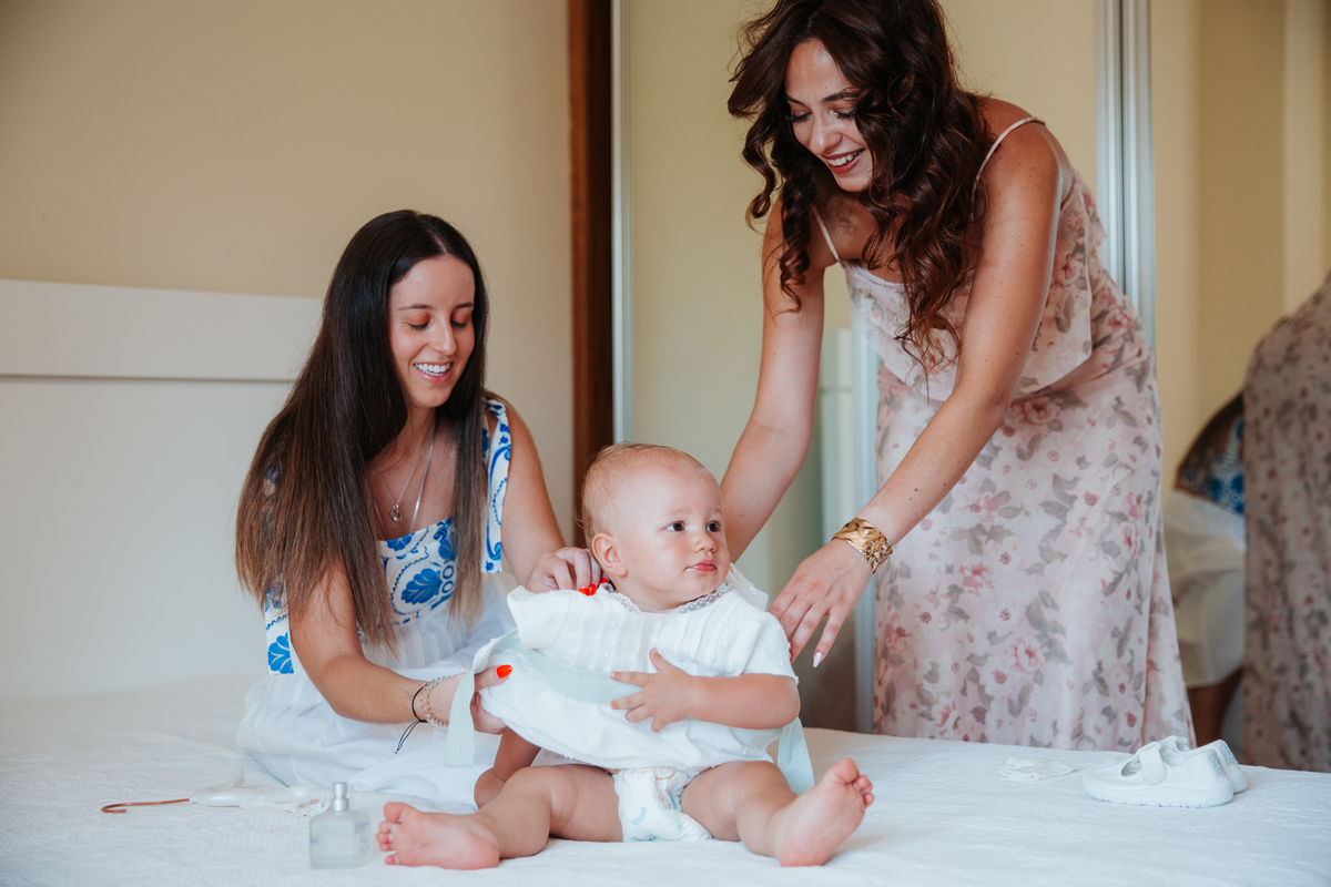 Momento de cumplicidade e sorrisos na reportagem fotográfica de batizado de família.