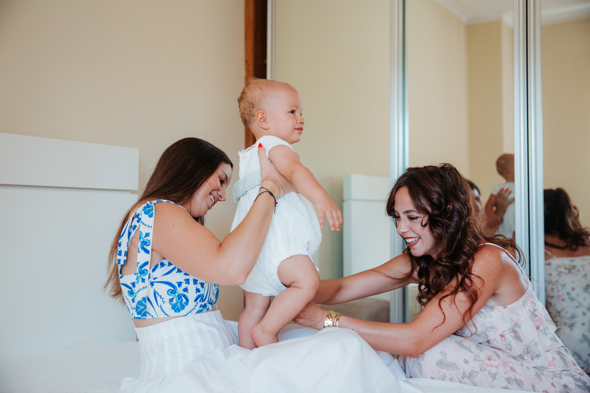 Momento de cumplicidade e sorrisos na reportagem fotográfica de batizado de família.