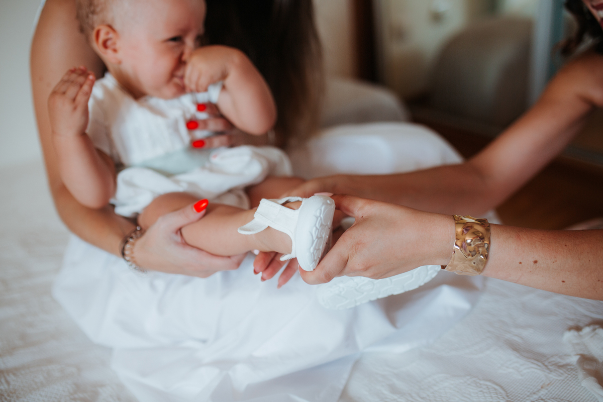 Momento de cumplicidade e sorrisos na reportagem fotográfica de batizado de família.