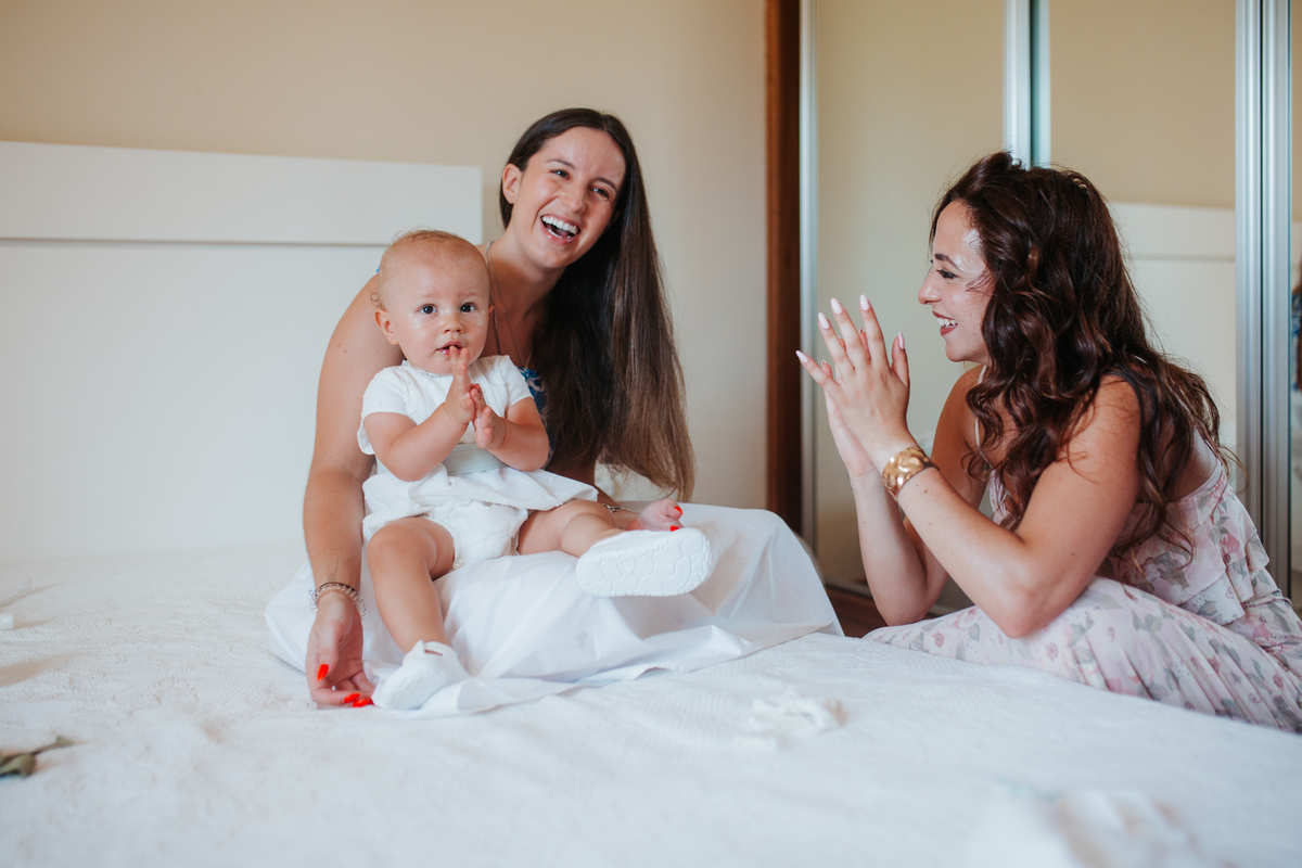 Momento de cumplicidade e sorrisos na reportagem fotográfica de batizado de família.