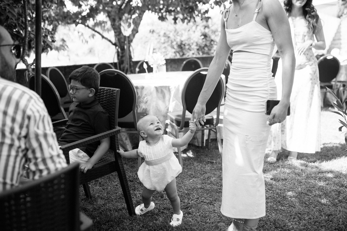 Momento de cumplicidade e sorrisos na reportagem fotográfica de batizado de família.
