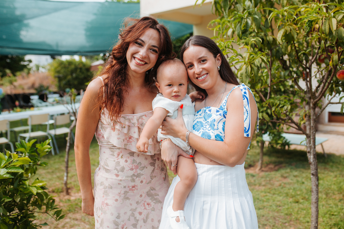 Momento de cumplicidade e sorrisos na reportagem fotográfica de batizado de família.