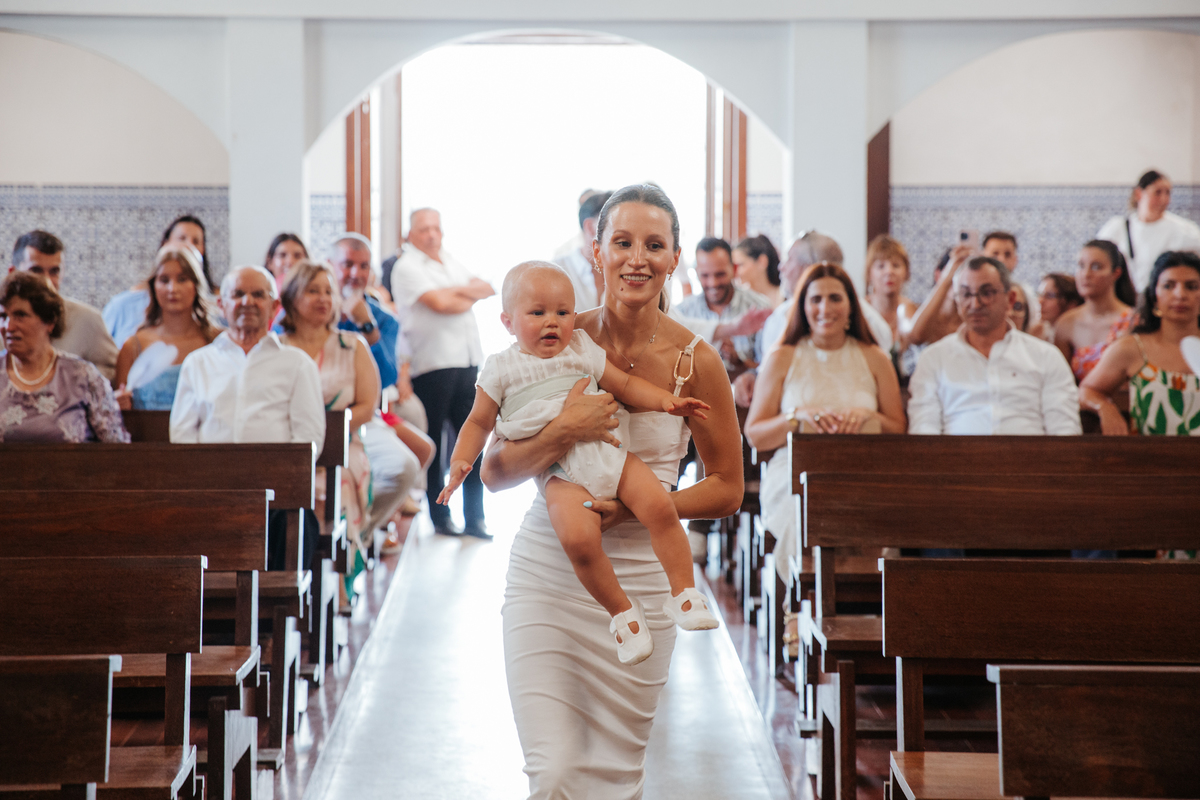 Momento de cumplicidade e sorrisos na reportagem fotográfica de batizado de família.