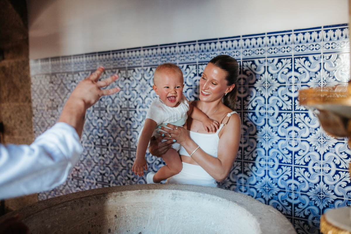 Momento de cumplicidade e sorrisos na reportagem fotográfica de batizado de família.