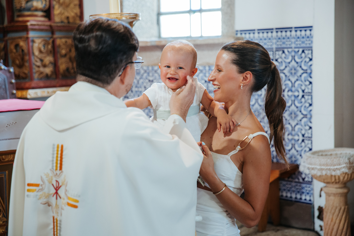 Momento de cumplicidade e sorrisos na reportagem fotográfica de batizado de família.