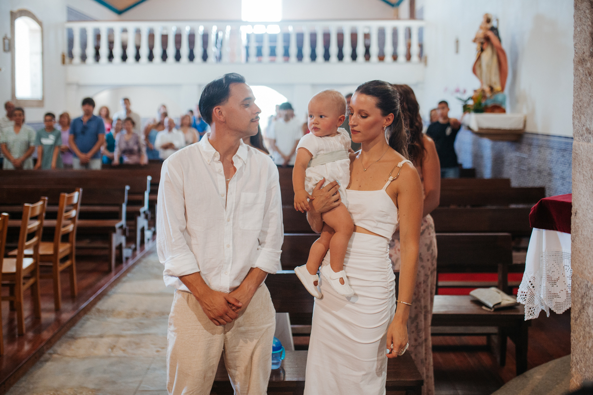 Momento de cumplicidade e sorrisos na reportagem fotográfica de batizado de família.