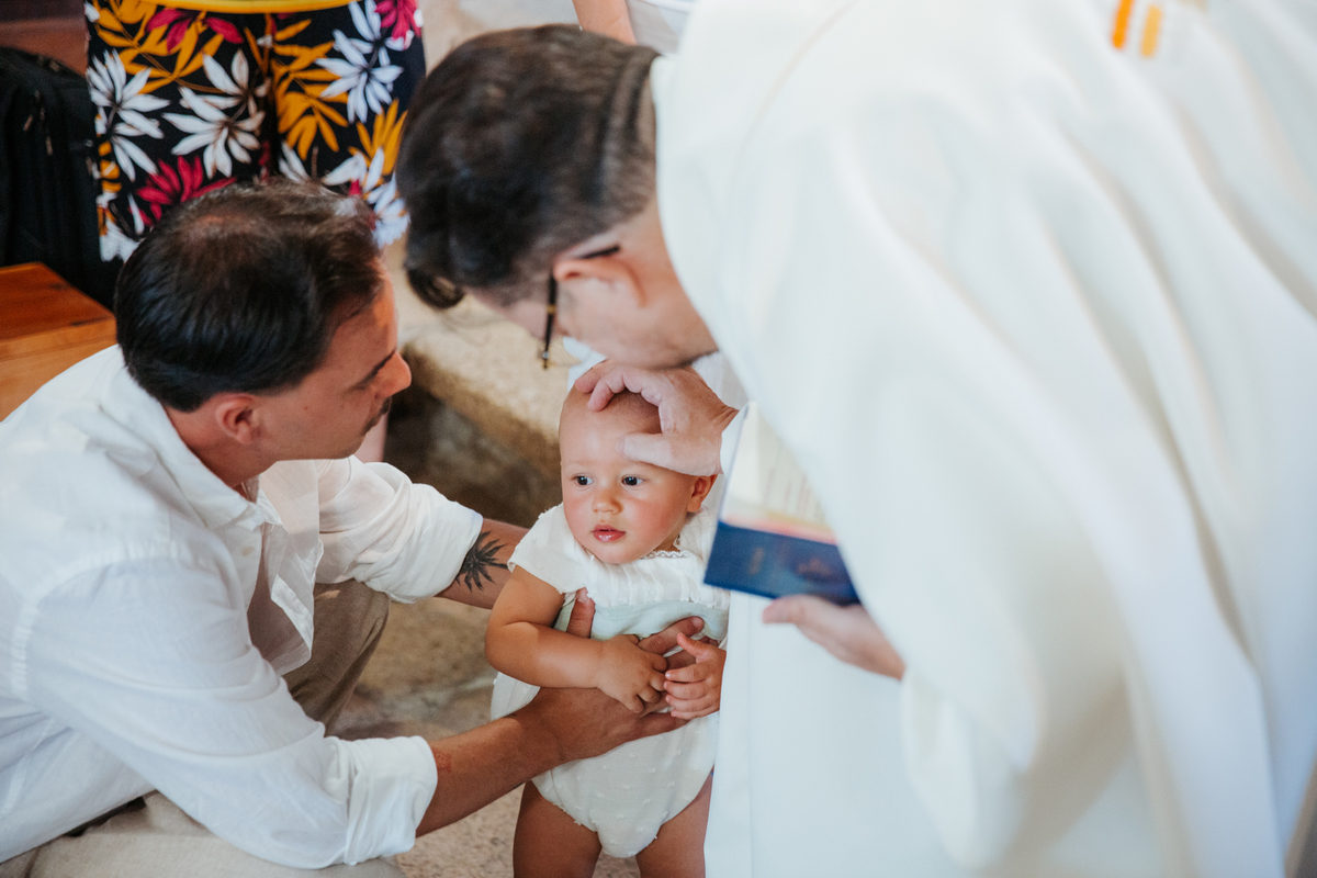 Momento de cumplicidade e sorrisos na reportagem fotográfica de batizado de família.