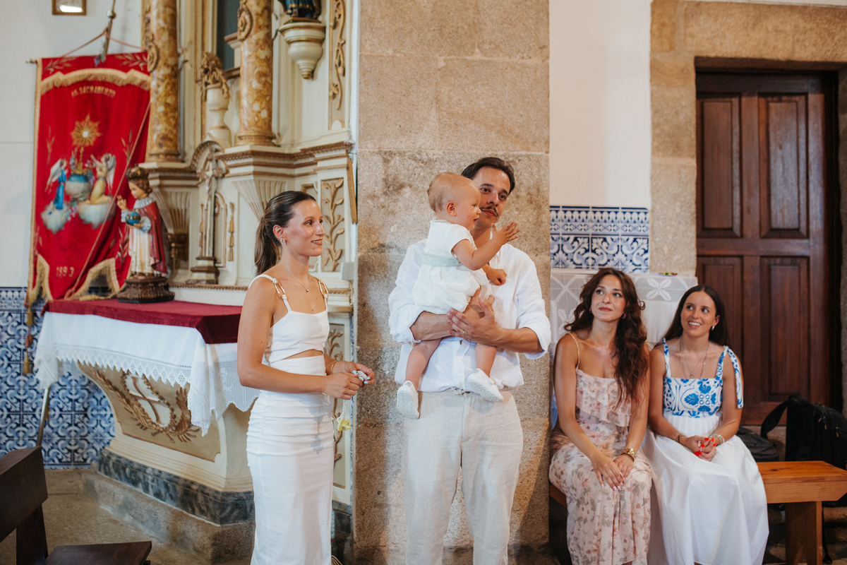 Momento de cumplicidade e sorrisos na reportagem fotográfica de batizado de família.