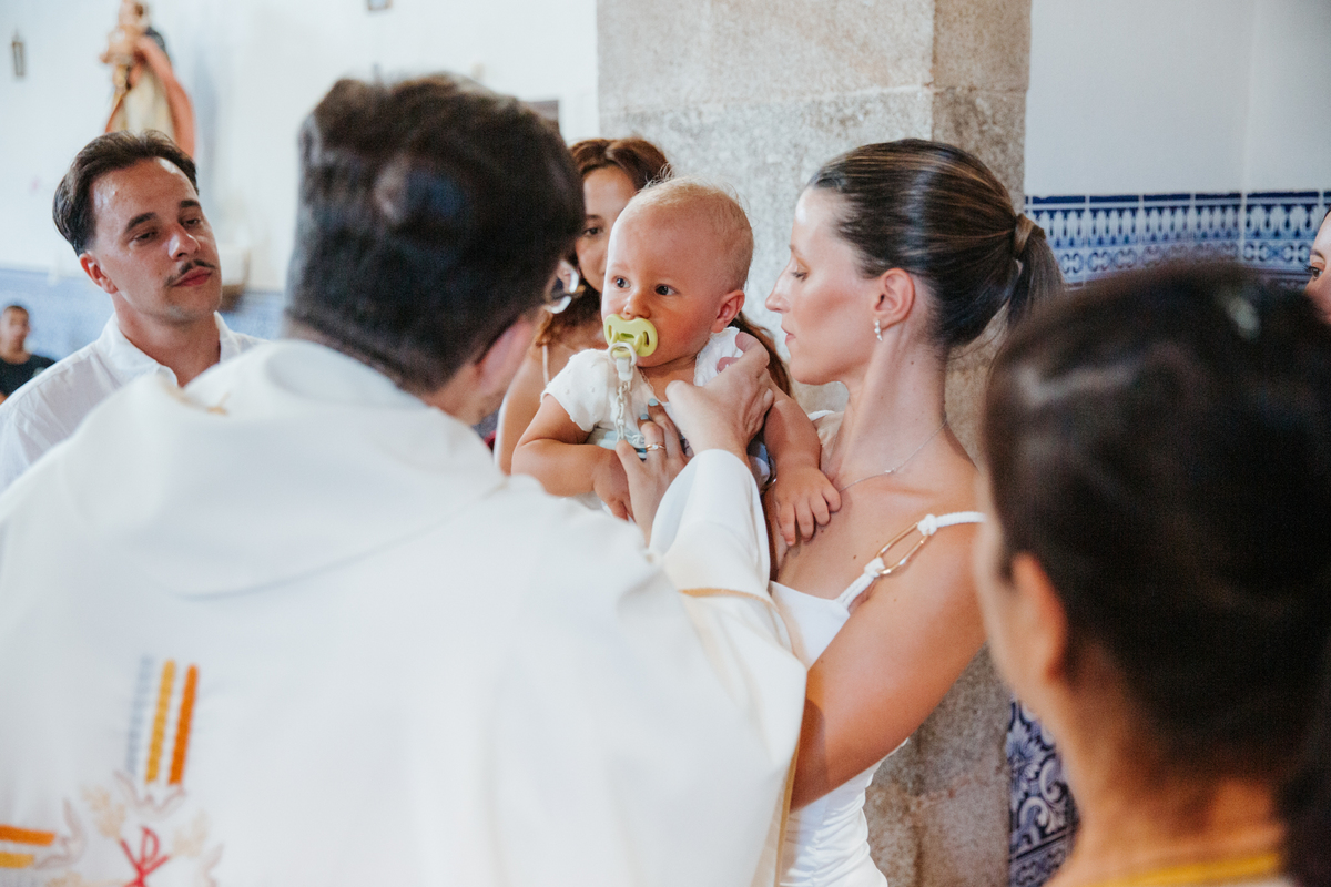 Momento de cumplicidade e sorrisos na reportagem fotográfica de batizado de família.
