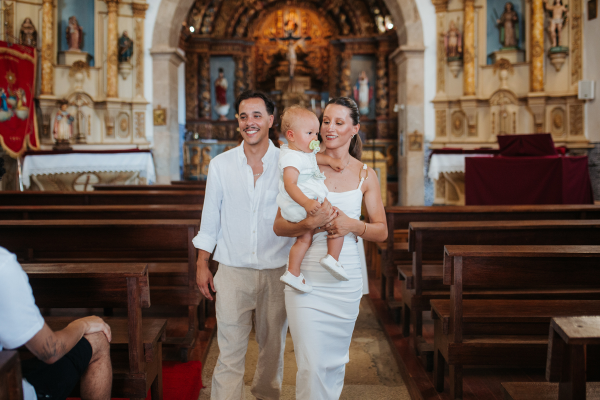 Momento de cumplicidade e sorrisos na reportagem fotográfica de batizado de família.