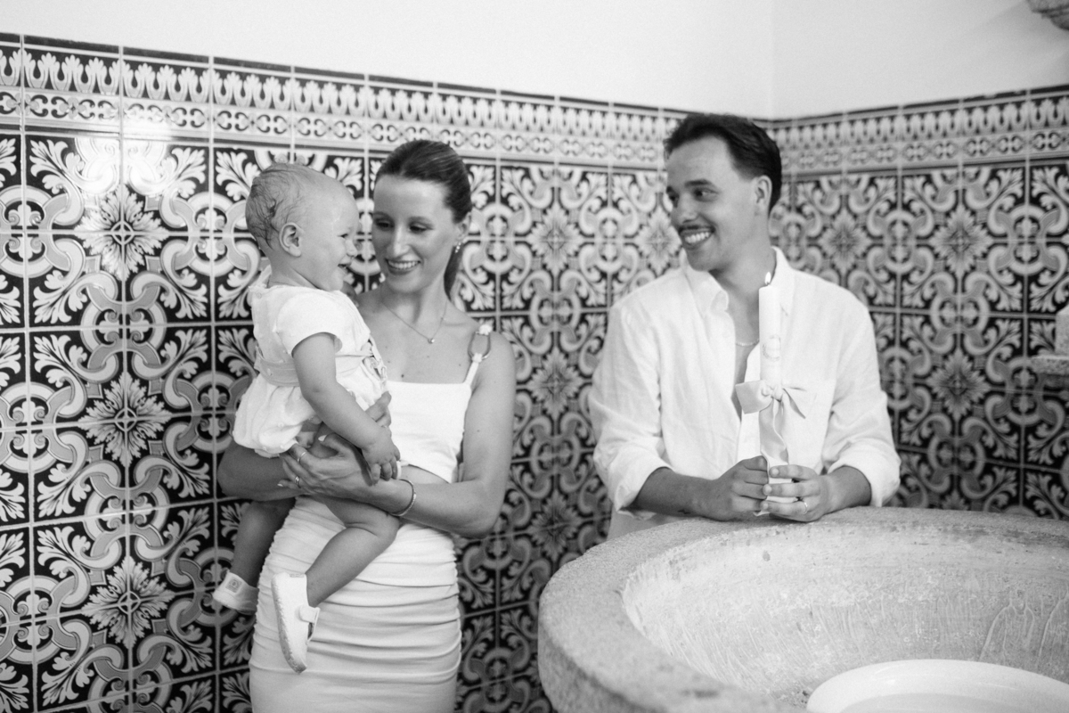 Momento de cumplicidade e sorrisos na reportagem fotográfica de batizado de família.