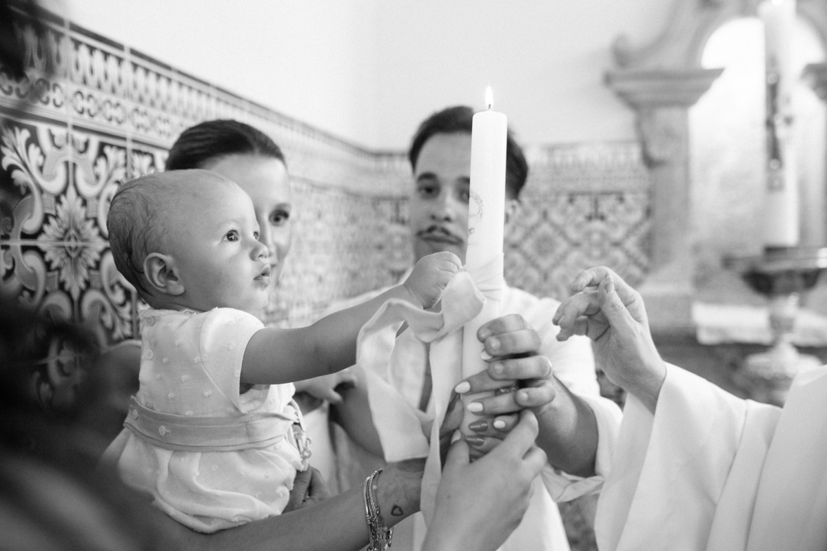 Momento de cumplicidade e sorrisos na reportagem fotográfica de batizado de família.
