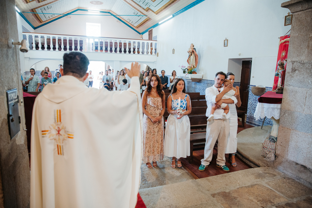 Momento de cumplicidade e sorrisos na reportagem fotográfica de batizado de família.