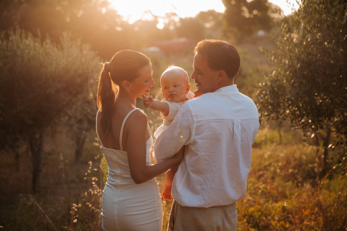 Momento de cumplicidade e sorrisos na reportagem fotográfica de batizado de família.