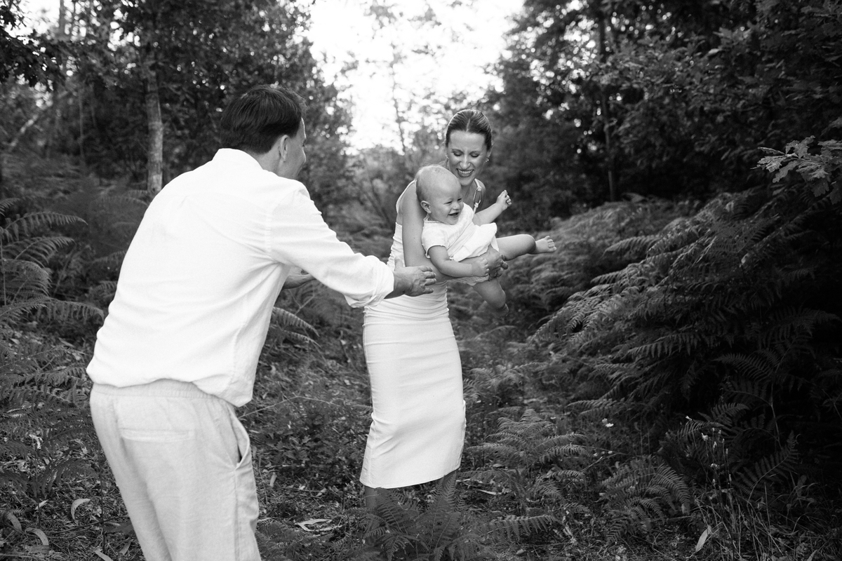 Momento de cumplicidade e sorrisos na reportagem fotográfica de batizado de família.