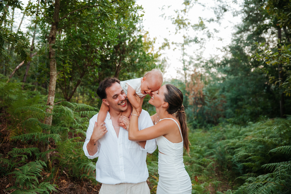 Momento de cumplicidade e sorrisos na reportagem fotográfica de batizado de família.