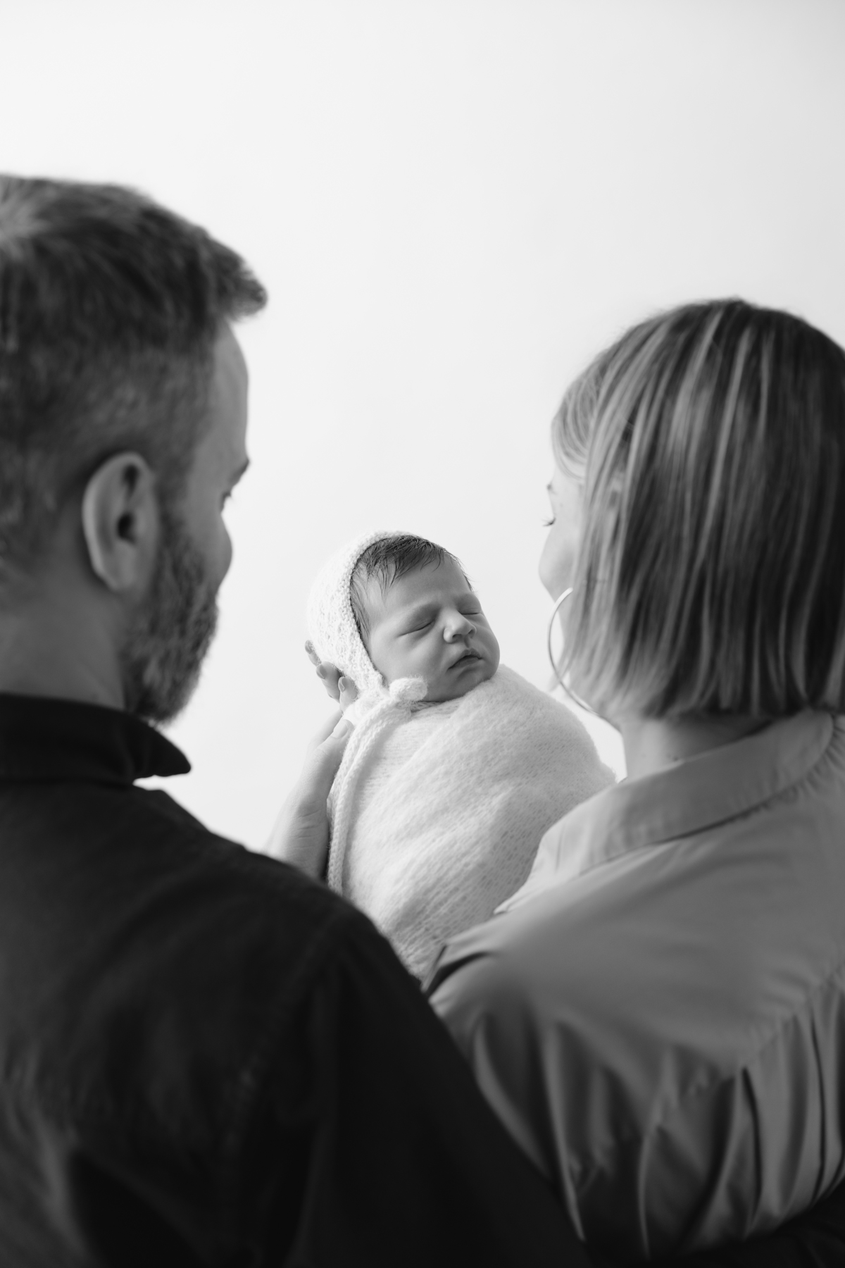 Fotografia de família com recém-nascido, celebrando a chegada do segundo filho com afeto.