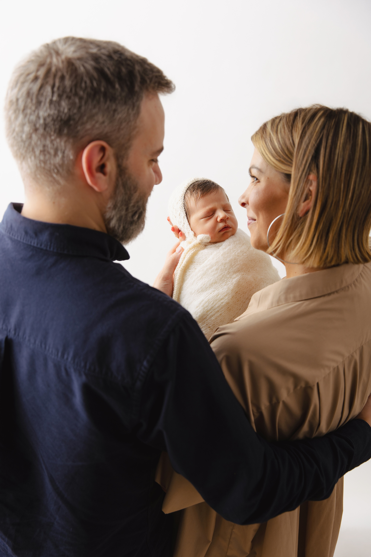 Fotografia de família com recém-nascido, celebrando a chegada do segundo filho com afeto.