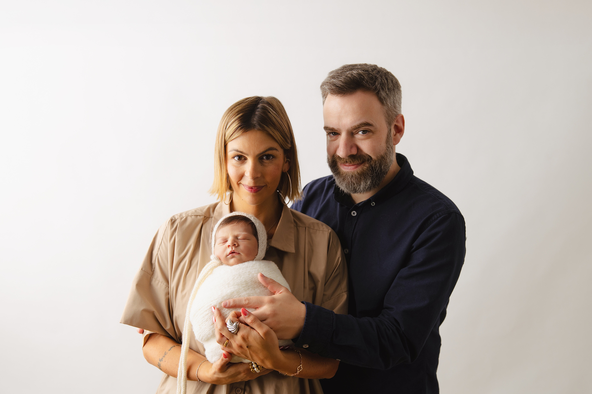 Fotografia de família com recém-nascido, celebrando a chegada do segundo filho com afeto.