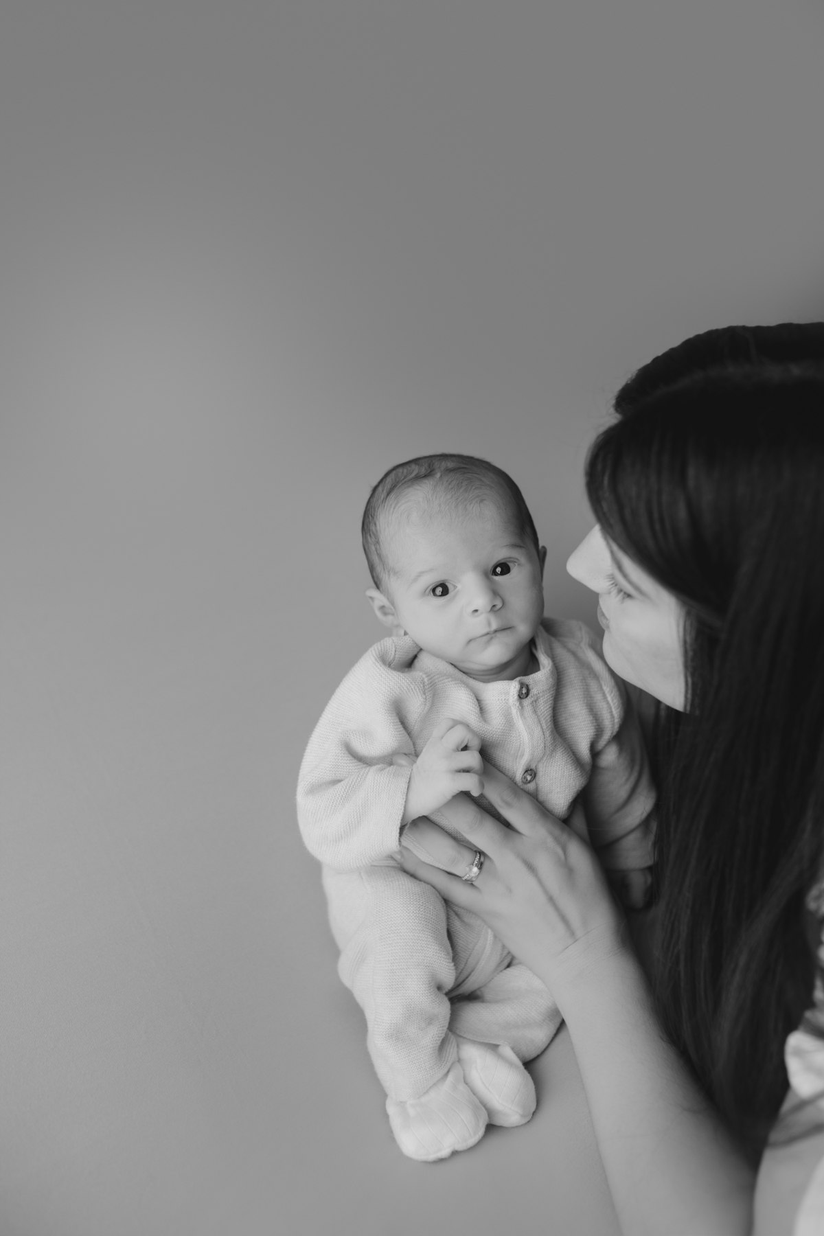Fotografia newborn com foco na expressão doce e serena do recém-nascido aos 27 dias.