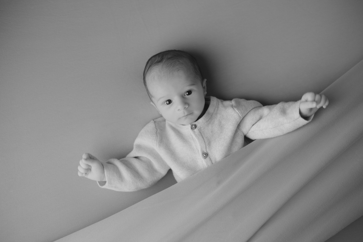 Fotografia newborn com foco na expressão doce e serena do recém-nascido aos 27 dias.