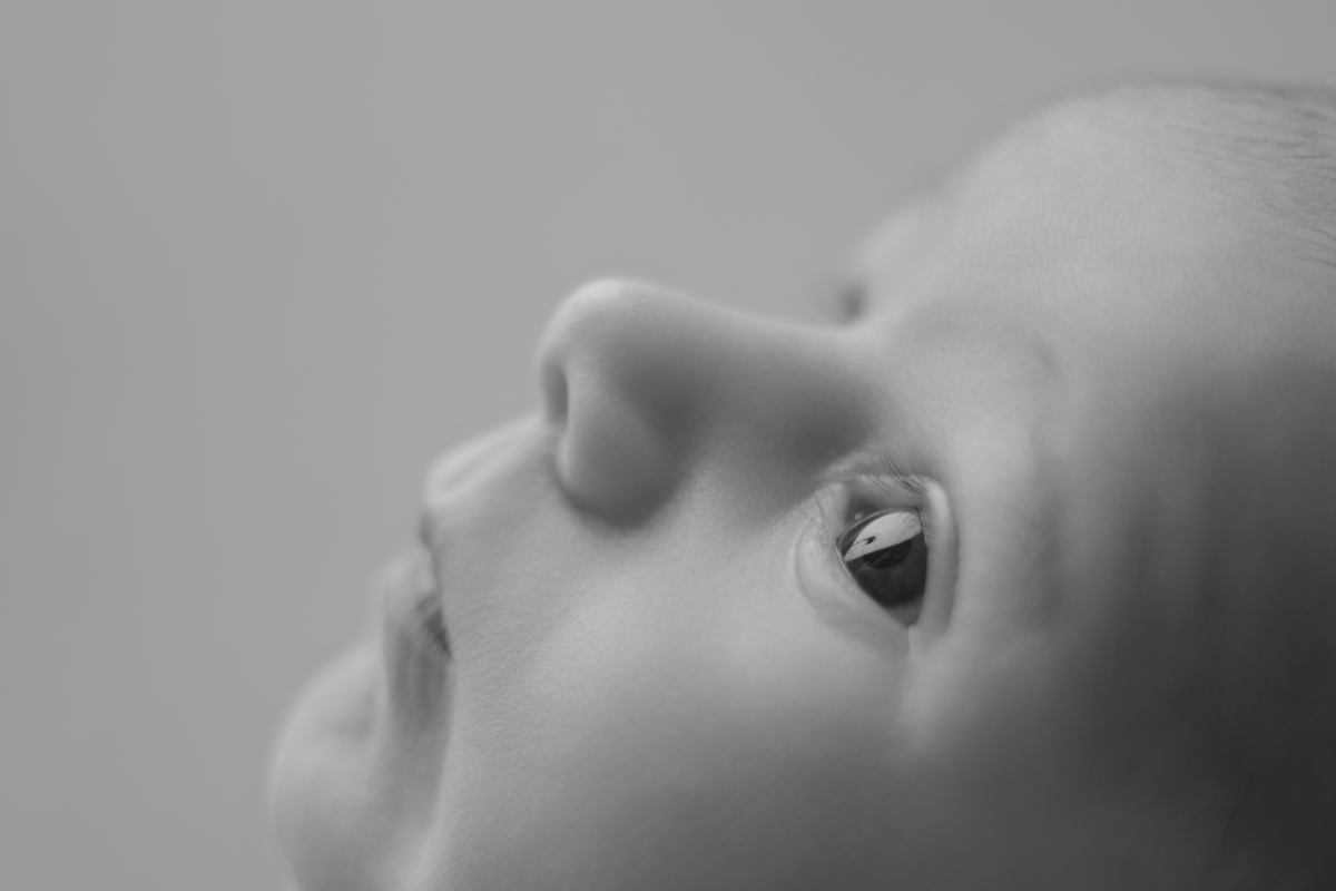 Fotografia newborn com foco na expressão doce e serena do recém-nascido aos 27 dias.
