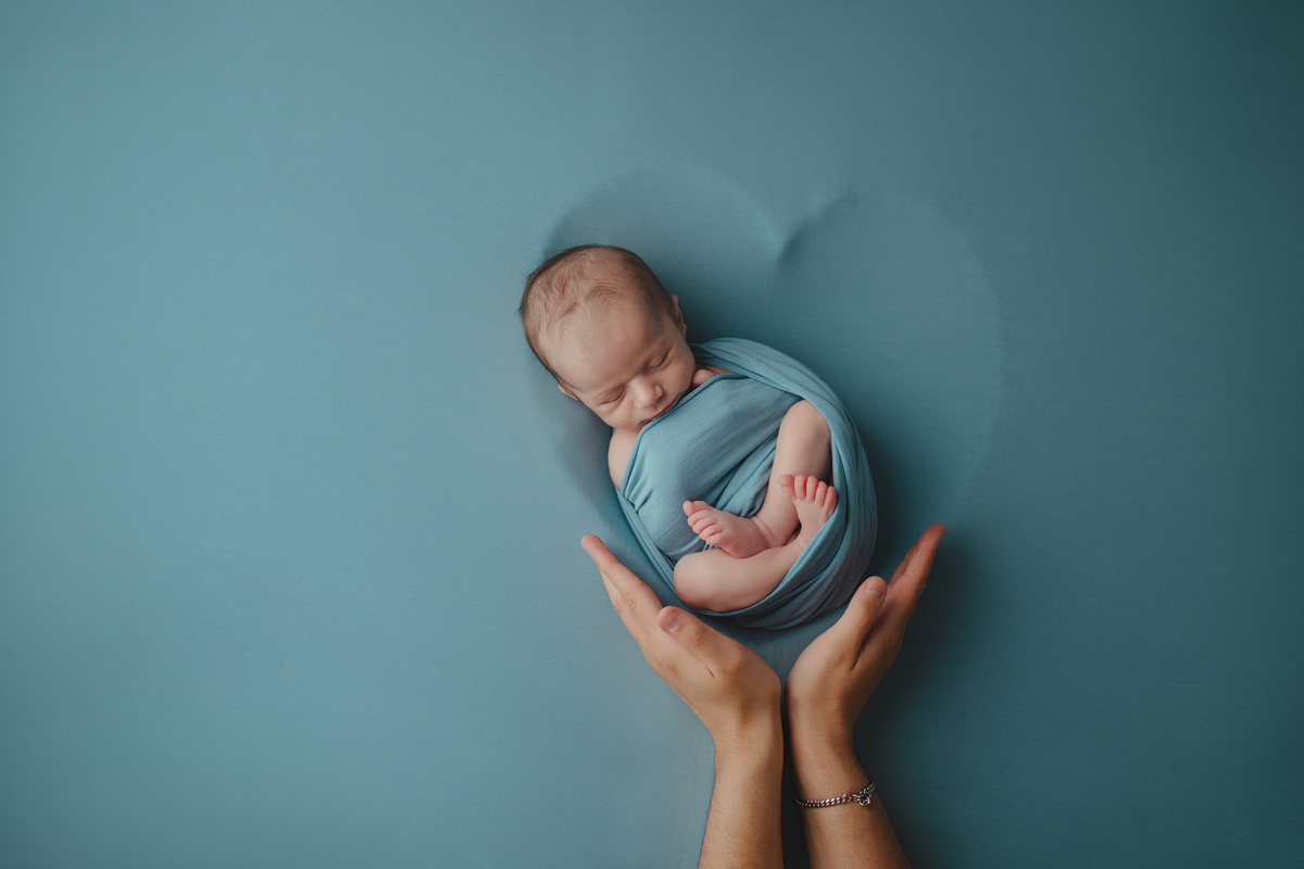 Fotografia newborn com foco na expressão doce e serena do recém-nascido aos 27 dias.