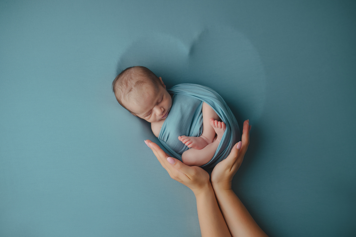 Fotografia newborn com foco na expressão doce e serena do recém-nascido aos 27 dias.