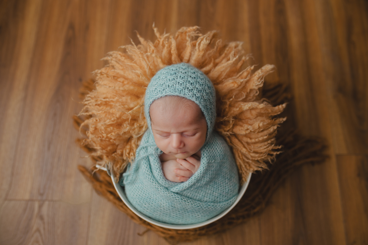 Fotografia newborn com foco na expressão doce e serena do recém-nascido aos 27 dias.