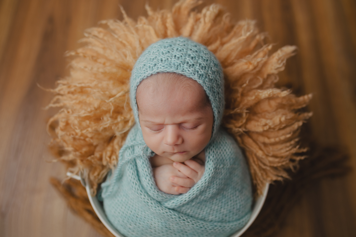 Fotografia newborn com foco na expressão doce e serena do recém-nascido aos 27 dias.