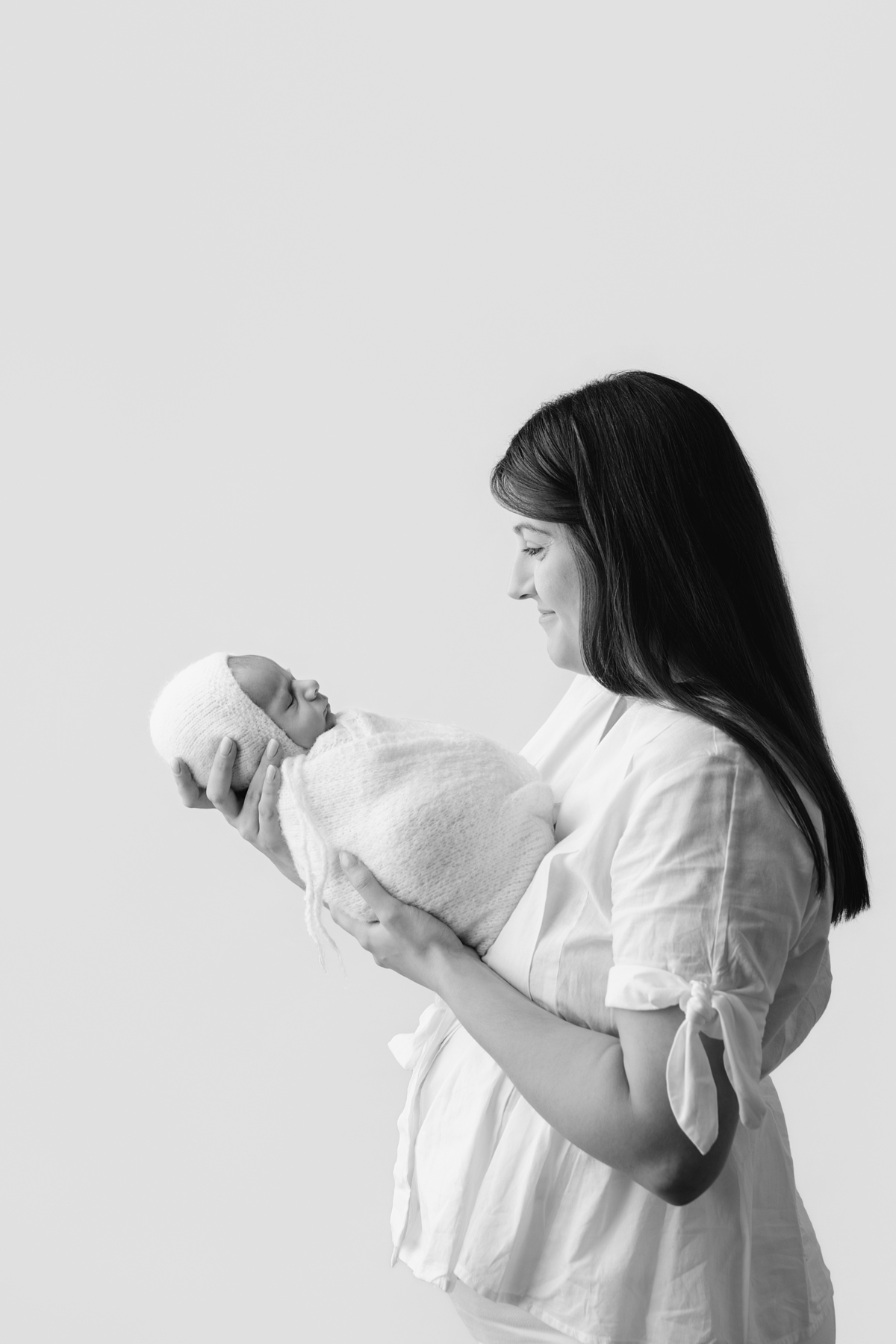 Fotografia newborn com foco na expressão doce e serena do recém-nascido aos 27 dias.