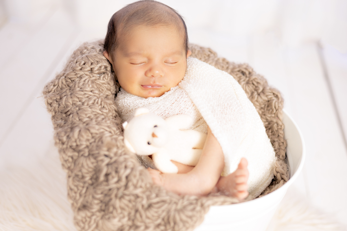 Bebe dentro do baldinho enrolado no tecido wrap