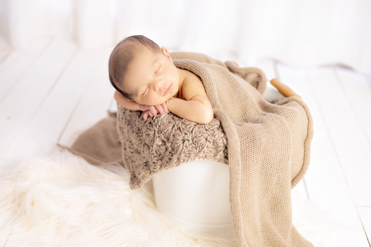 Bebe dentro do baldinho no ensaio newborn em são francisco do sul