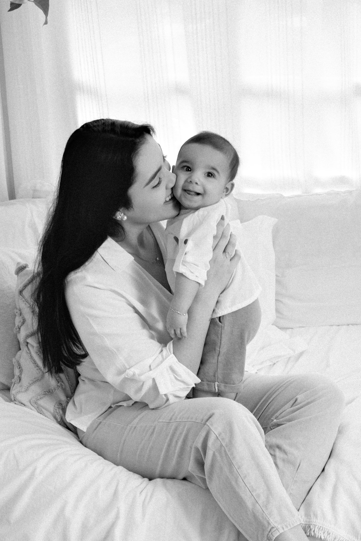 mãe dando beijinho no bebê preto e branco