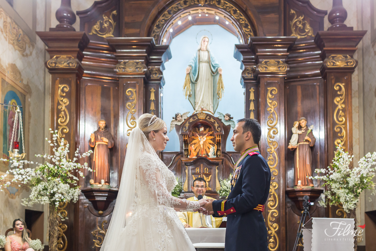 Noivos de frente um para o outro no altar. Imagem de Nossa Senhora das Graças
