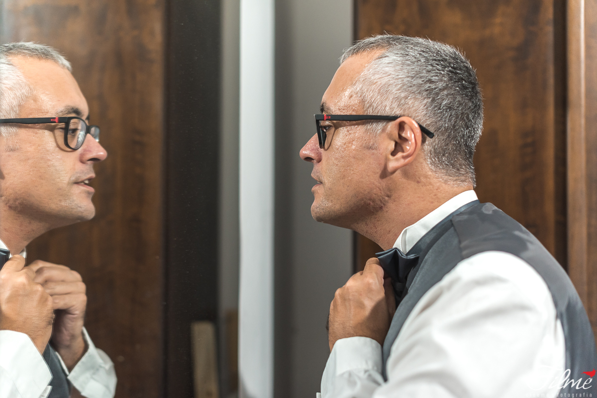 noivo apertando a gravata no espelho