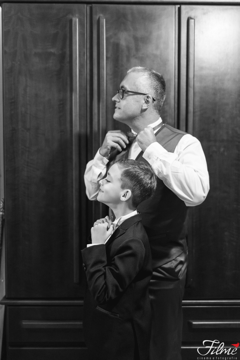 pai e filho ajeitando a gravata no espelho