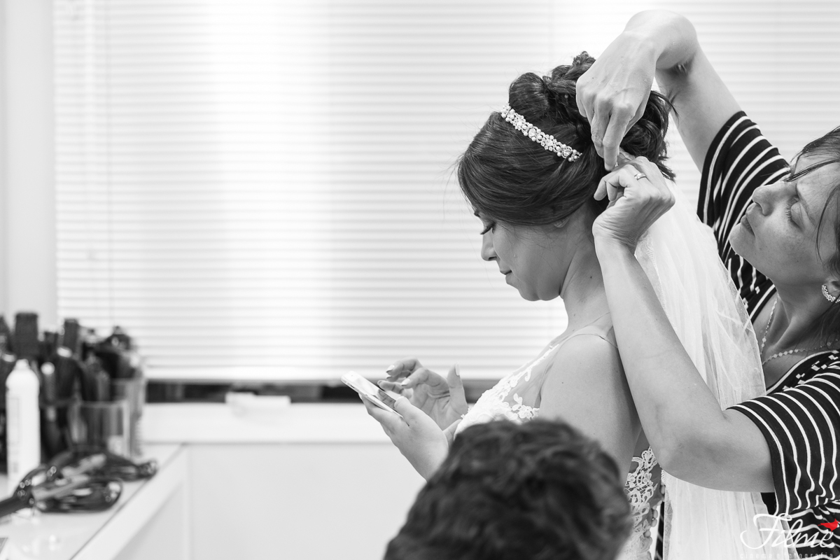 cabeleireira ajustando o véu da noiva
