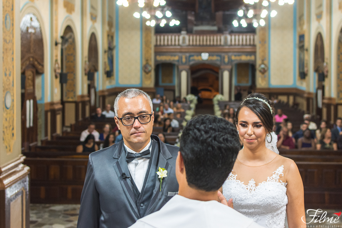 detalhe do padre, noivos e assembléia ao fundo na igreja nossa senhora das graças em Guaratinguetá