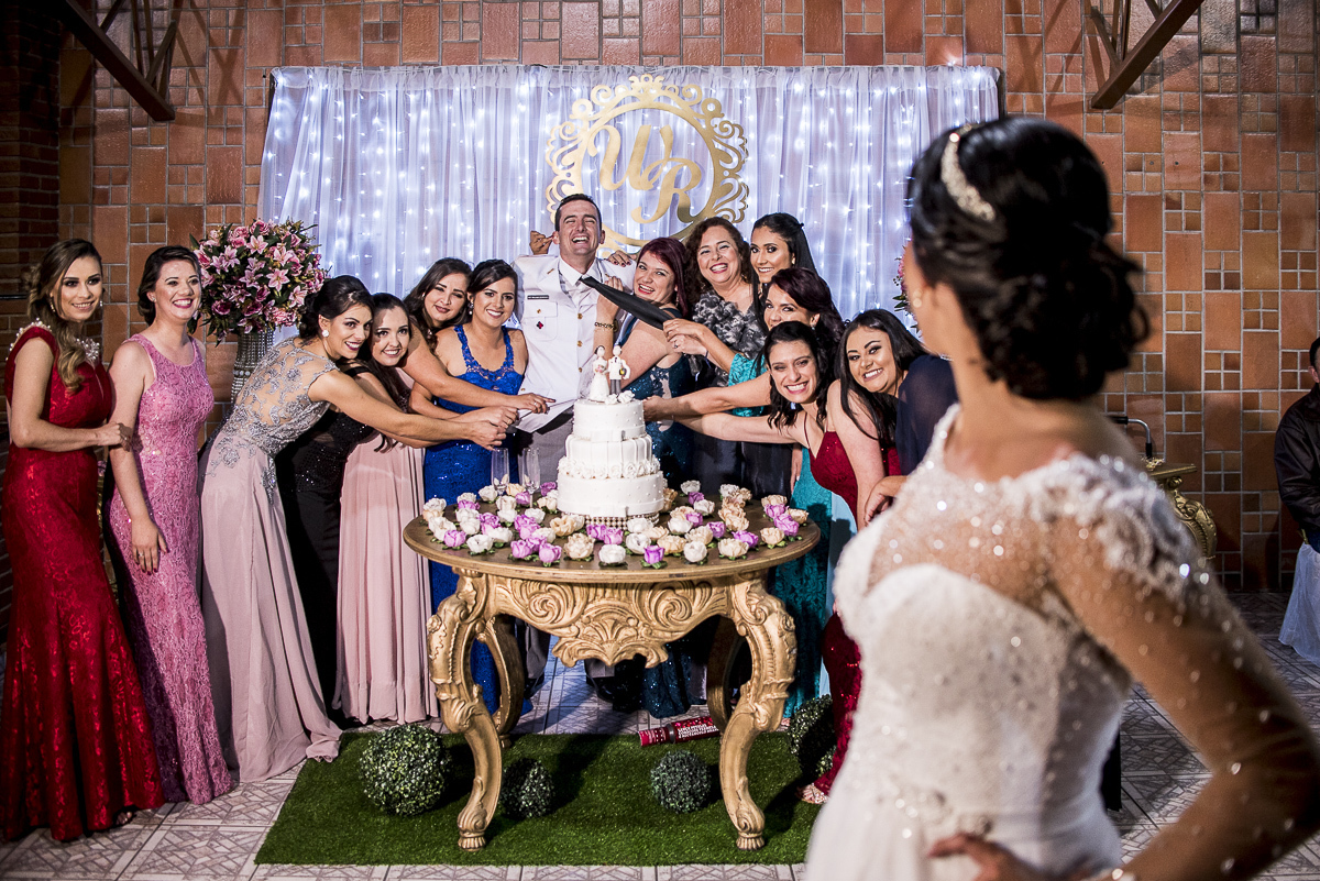 Noivo sendo abraçado pelas madrinhas