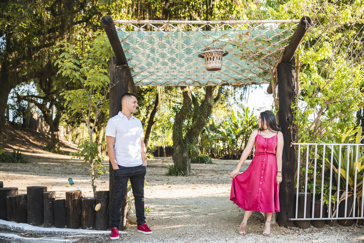 casal frente a um portico. vestido vermelho, tenis vermelho
