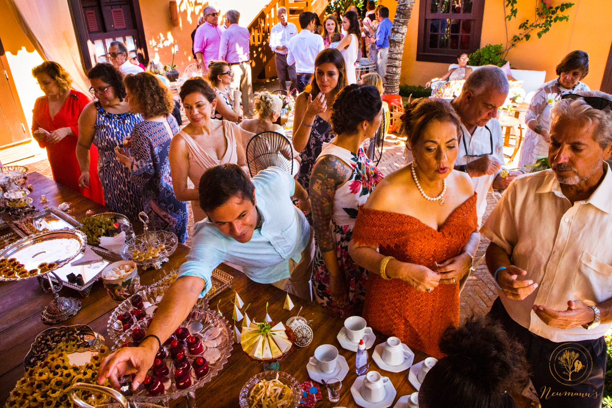 convidados se servindo em mesa de doces