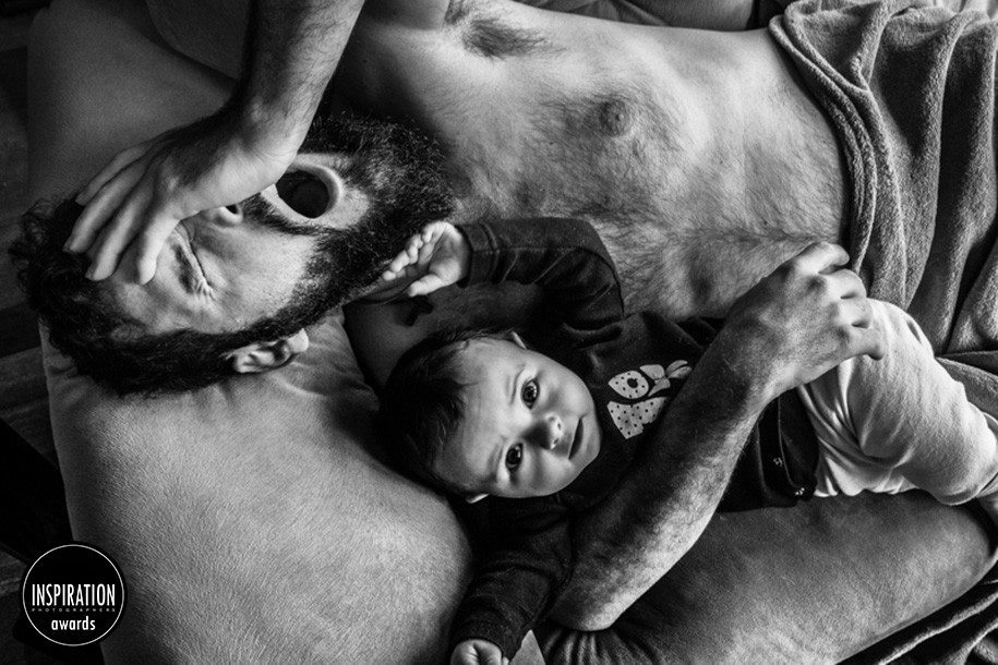 pai bocejando no sofá com bebe, foto Bia Neumann premiada no inspiration photographer