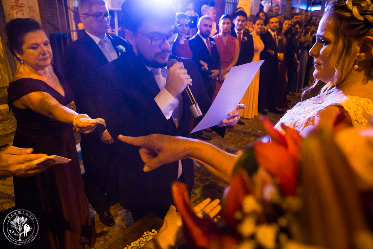 noivos trocando votos em cerimonia de casamento na Rua do ouvidor, noiva emocionada, e mãe do noivo entregando lenço de papel, foto neumanns fotografia