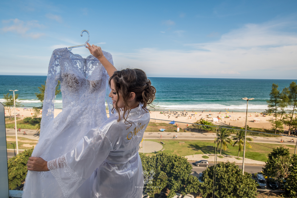 noiva na sacada admira seu vestido paisagem praia