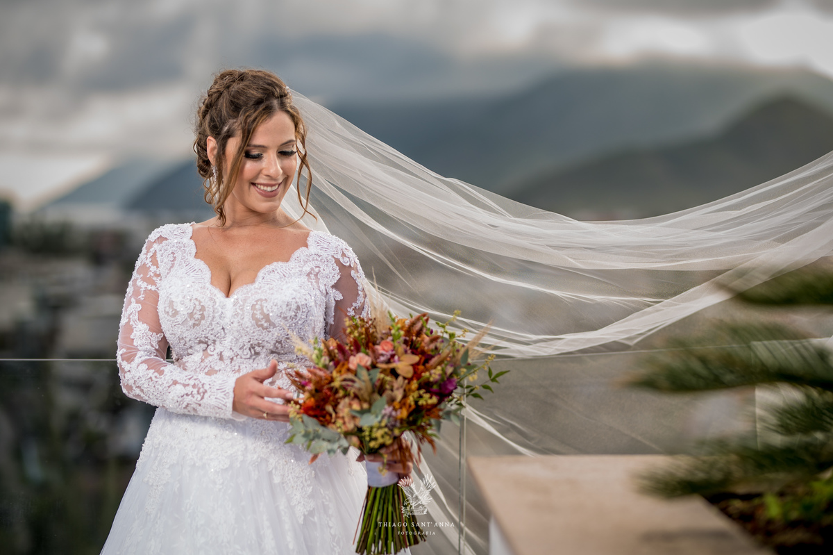 Noiva na sacada vestido buquê véu voando