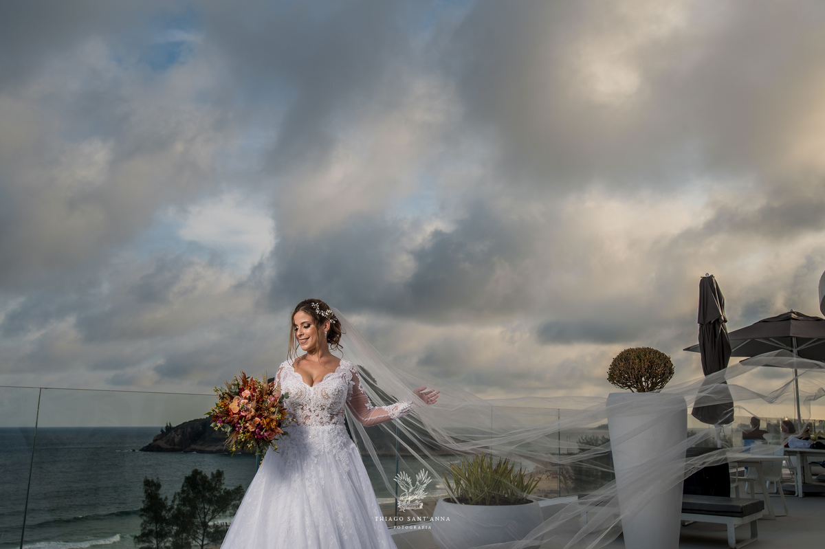 Noiva na sacada vestido buquê véu voando