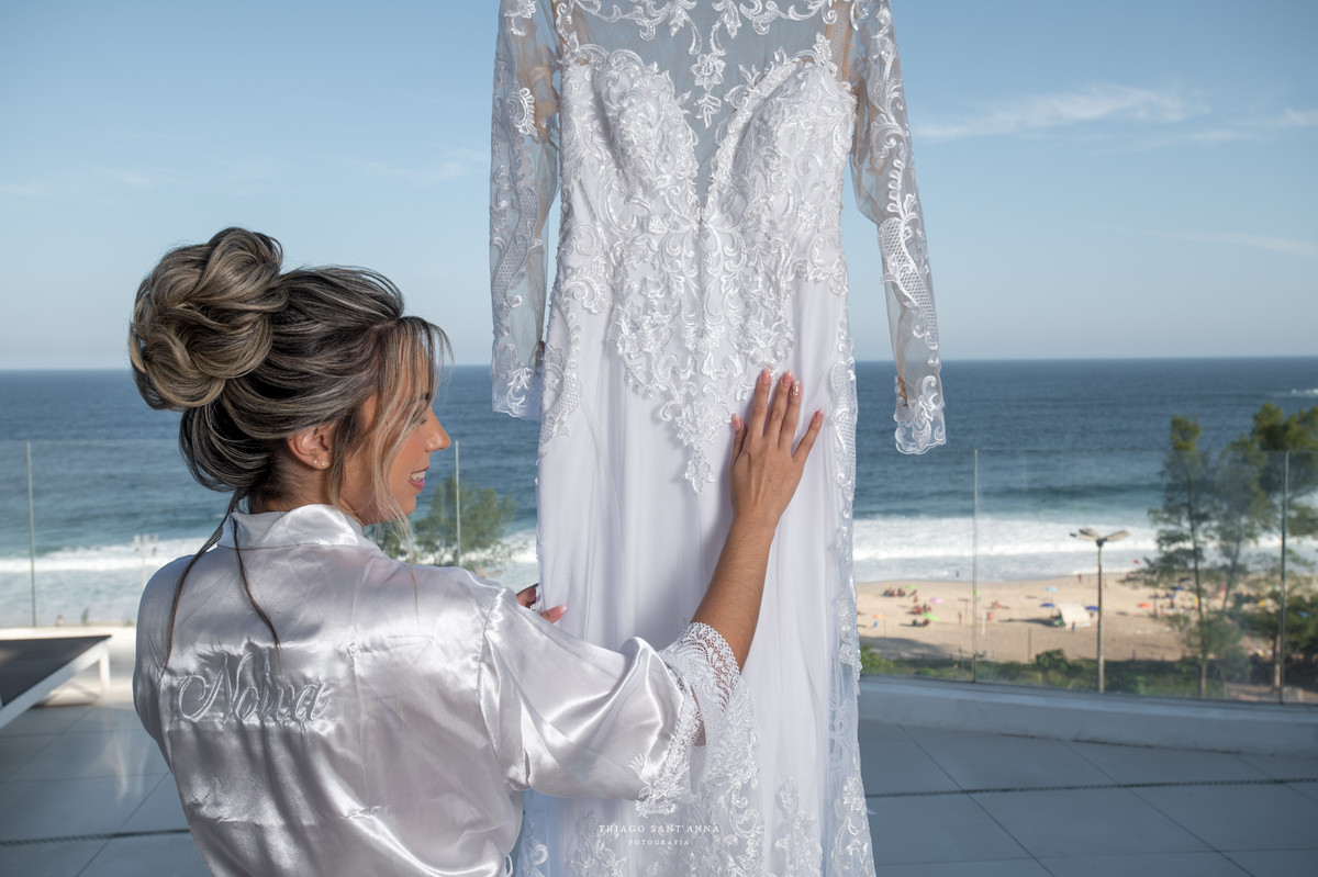 Noiva toca vestido pendurado paisagem praia