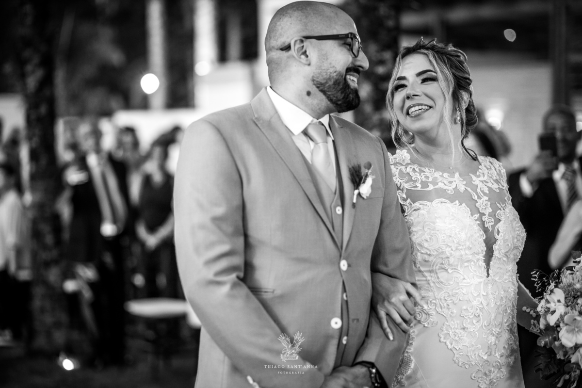 Noivos sorrindo no altar preto e branco